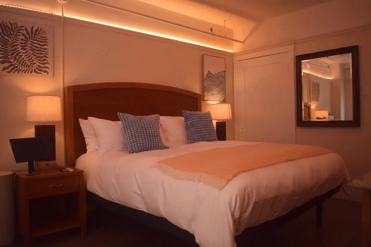 The Nook room at night, lit by warm cove lighting and bedside lamps